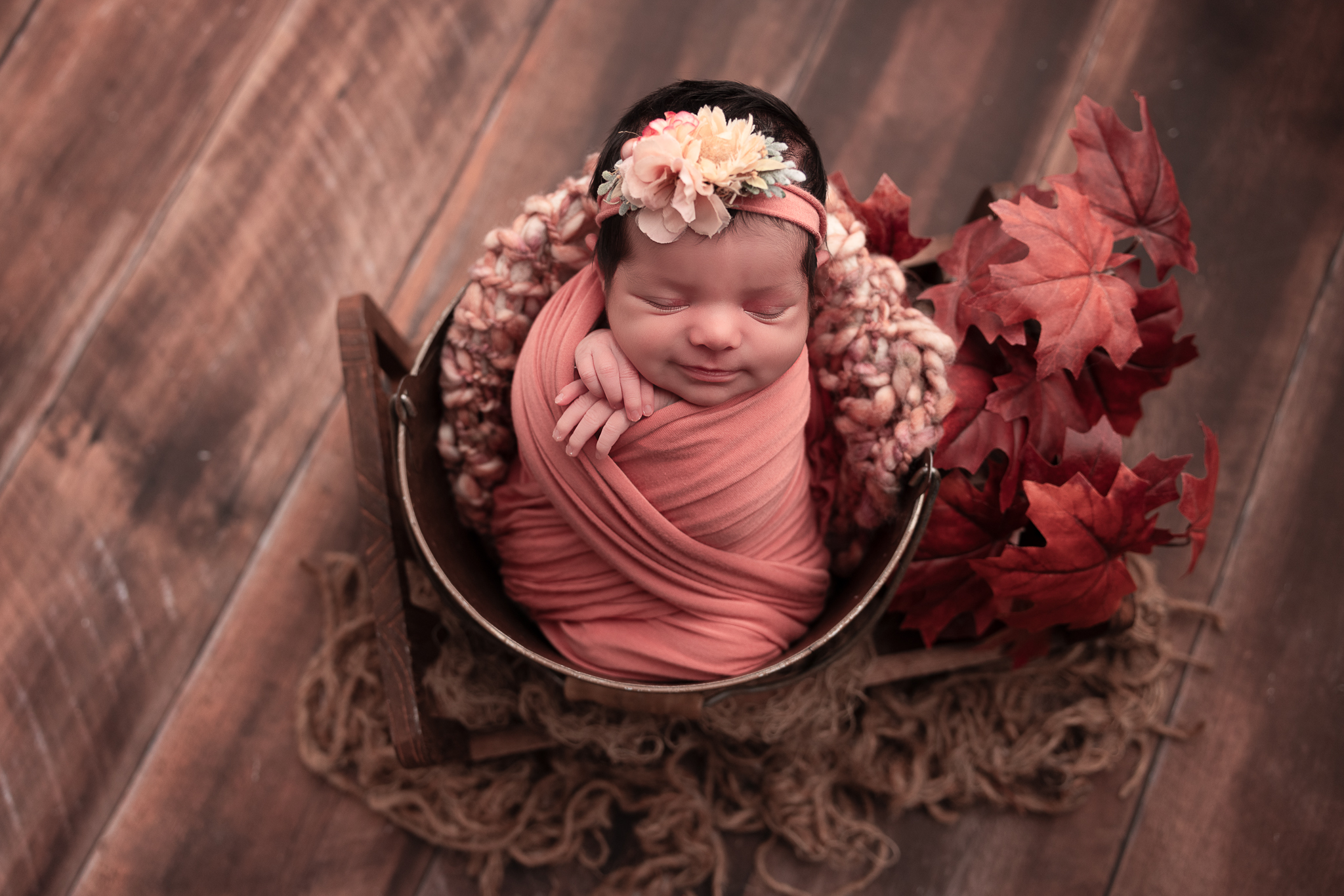 baby smiling with leaves for the fall