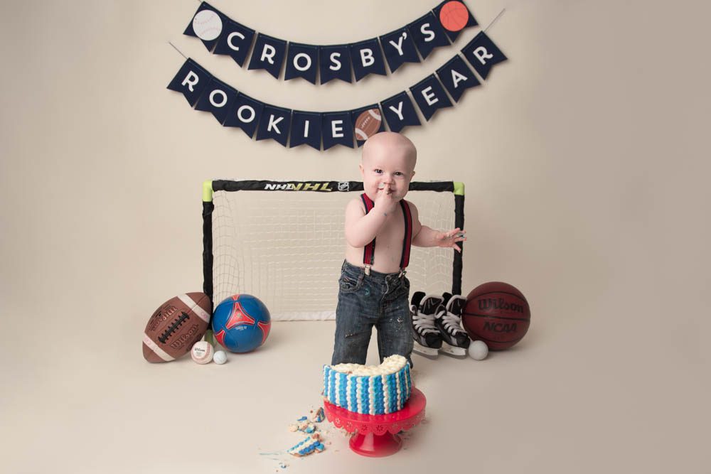 Rookie of the year banner with baby standing and eating cake