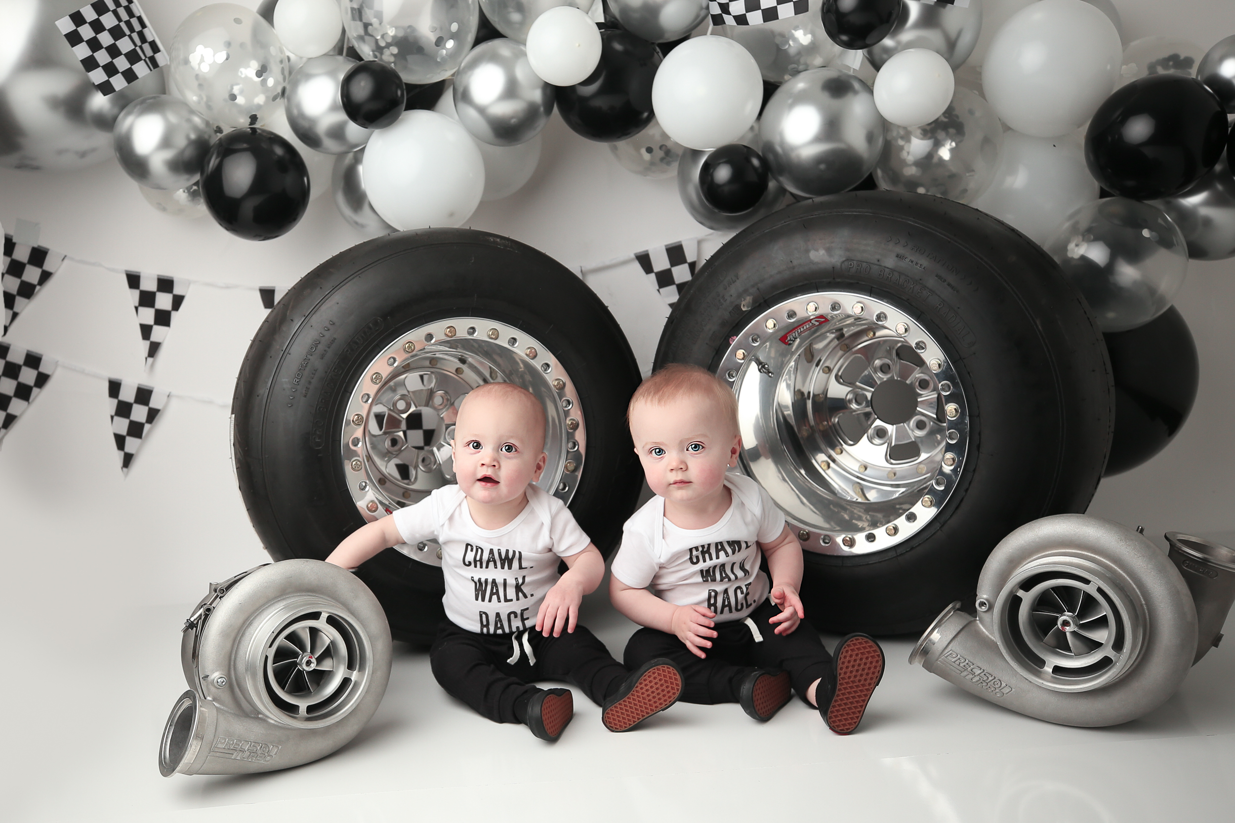 Twin Boys with Race Car Wheels and balloon banner in the backdrop