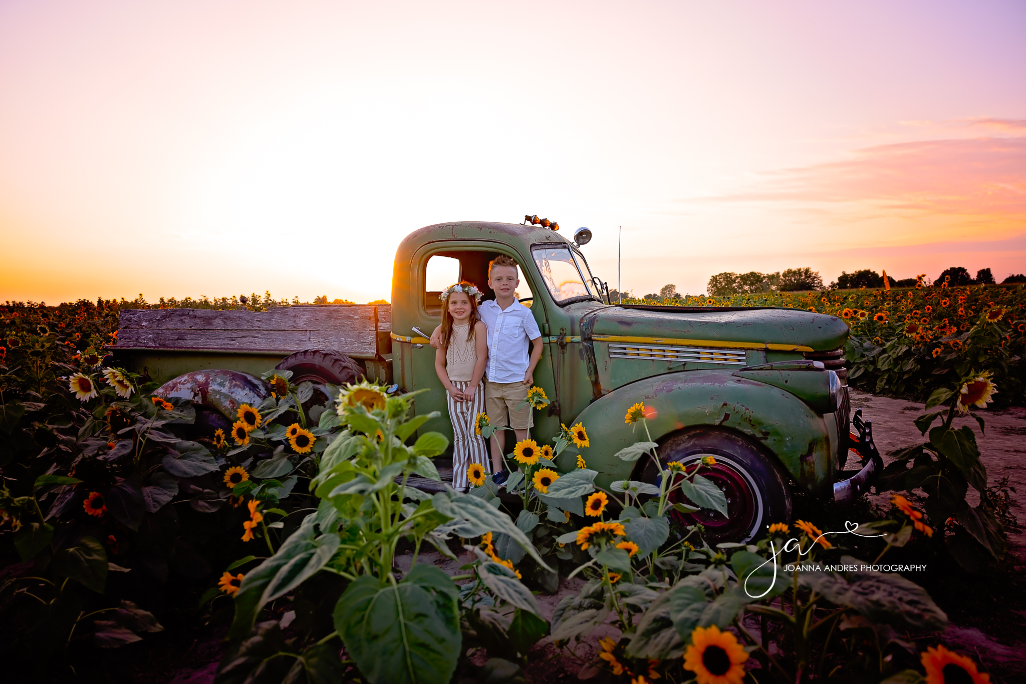 siblings on a vintage truck surrounded by sunflowers at lynd fruit farm