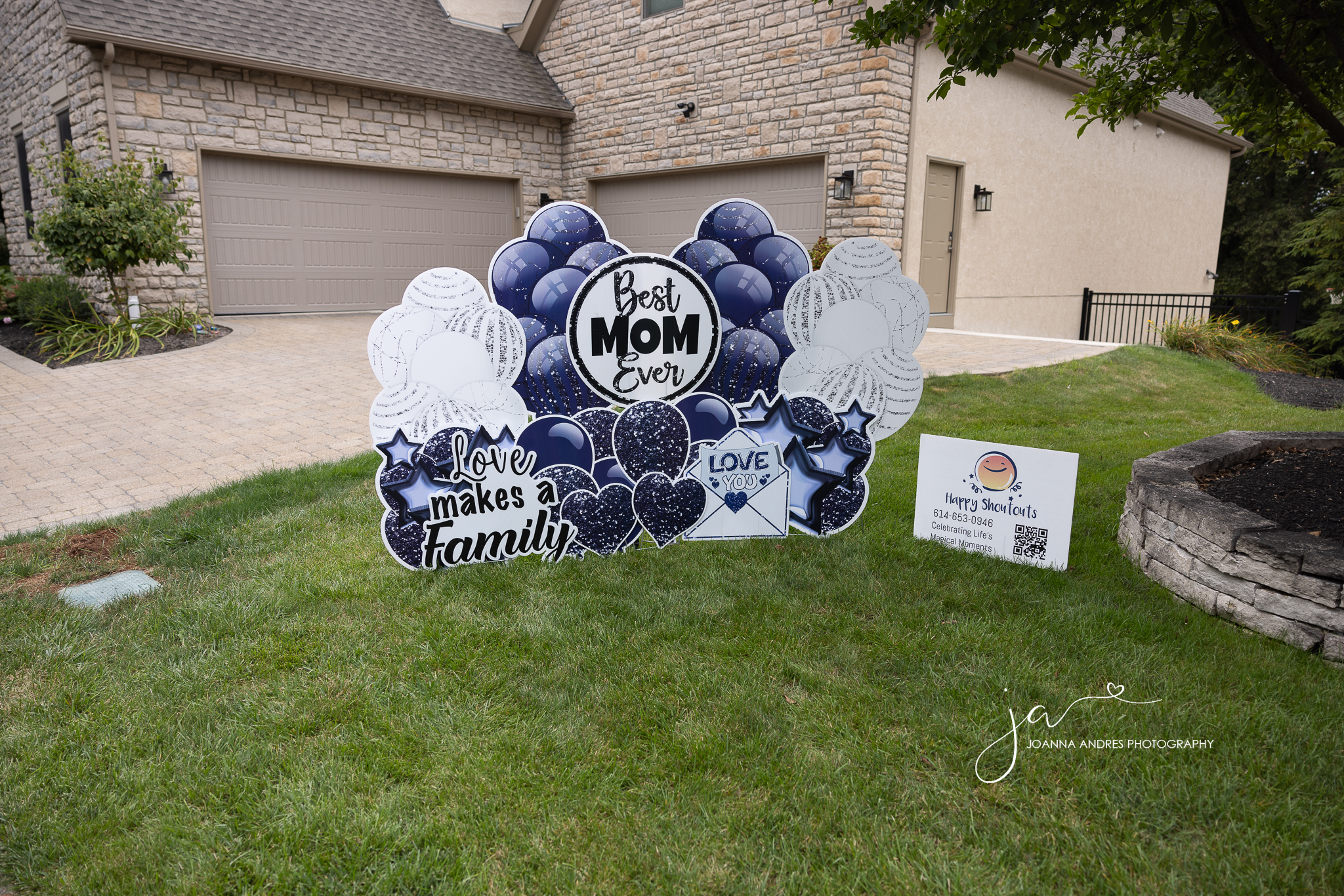 Yard sign that says best mom ever with photos of blue and white balloons