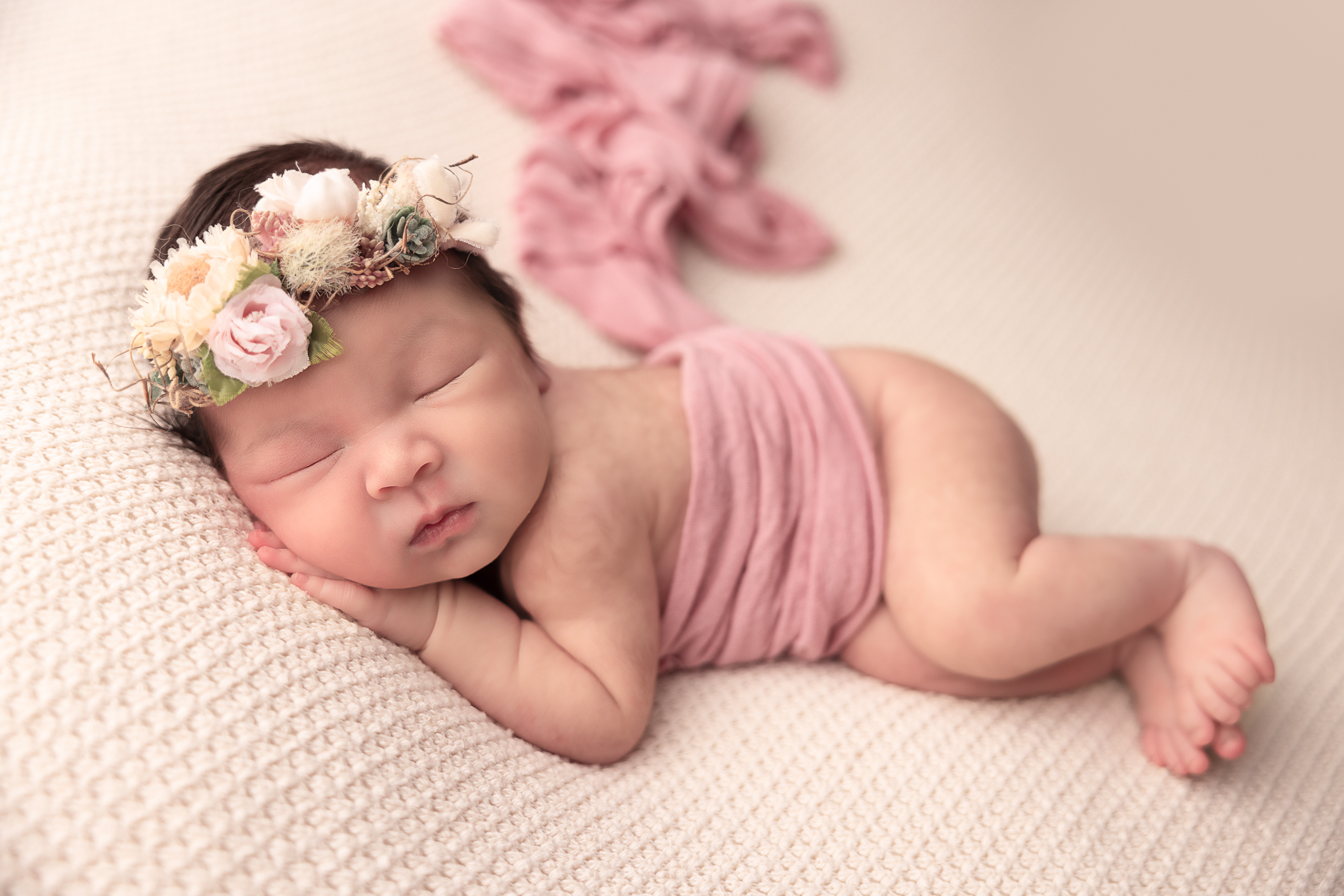 Baby sleeping side laying with pink wrap