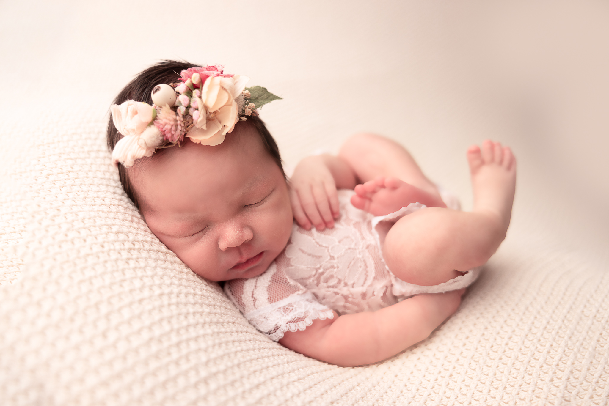 Huck Finn Pose of baby wearing a lace romper and floral headband