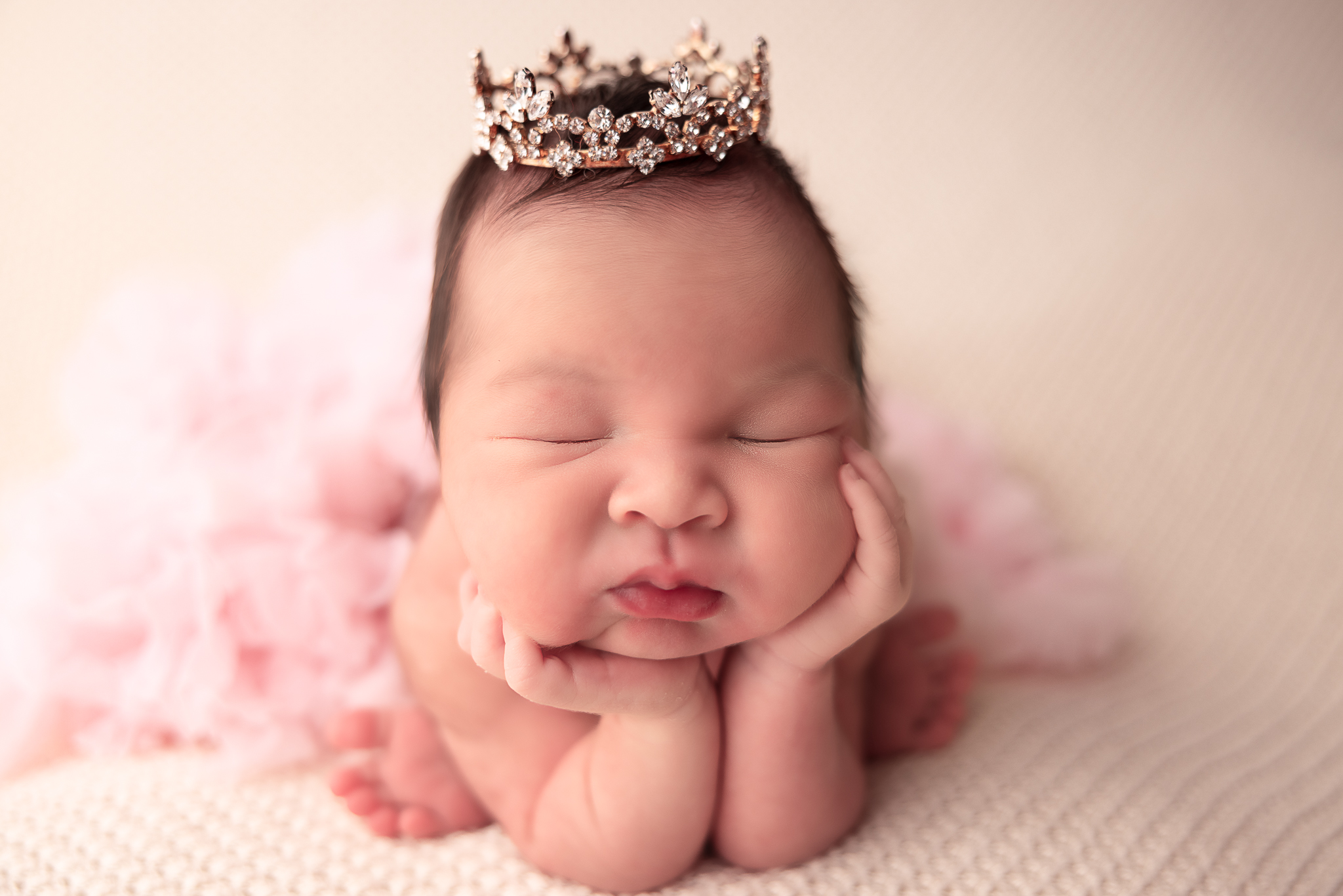 froggy pose of baby with large crown wearing a tutu