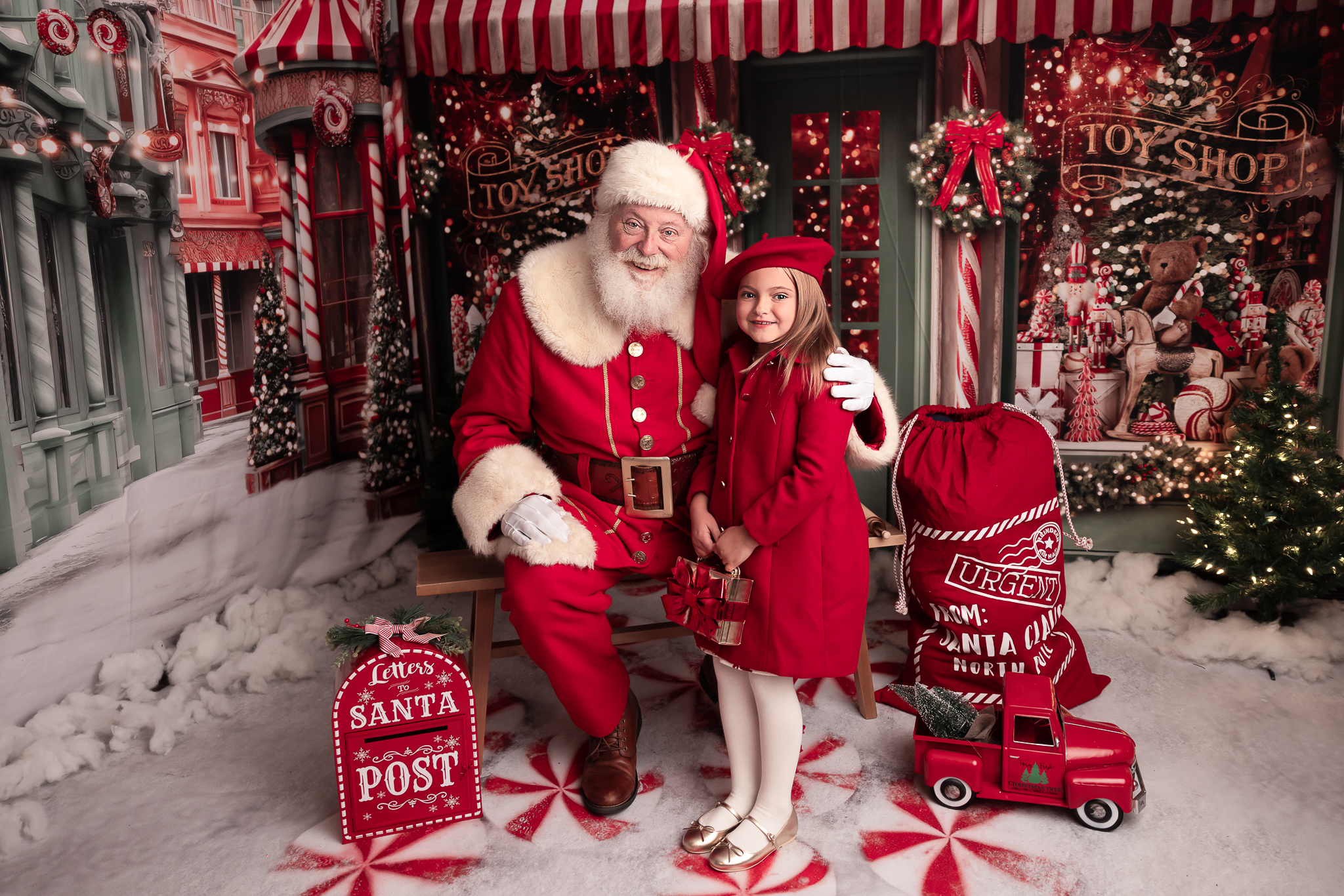 little girl dressed in red coat and holding a purse that looks like a gift and shes standing next to santa 