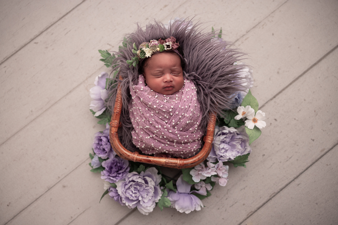 baby wrapped in purples with purple florals 