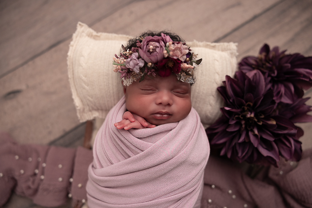 close up of babys face with floral headband