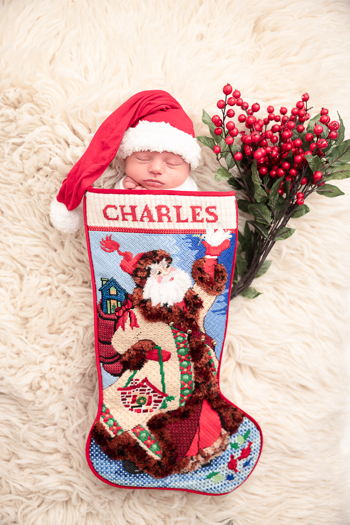 Baby in a festive Christmas stocking that says charles