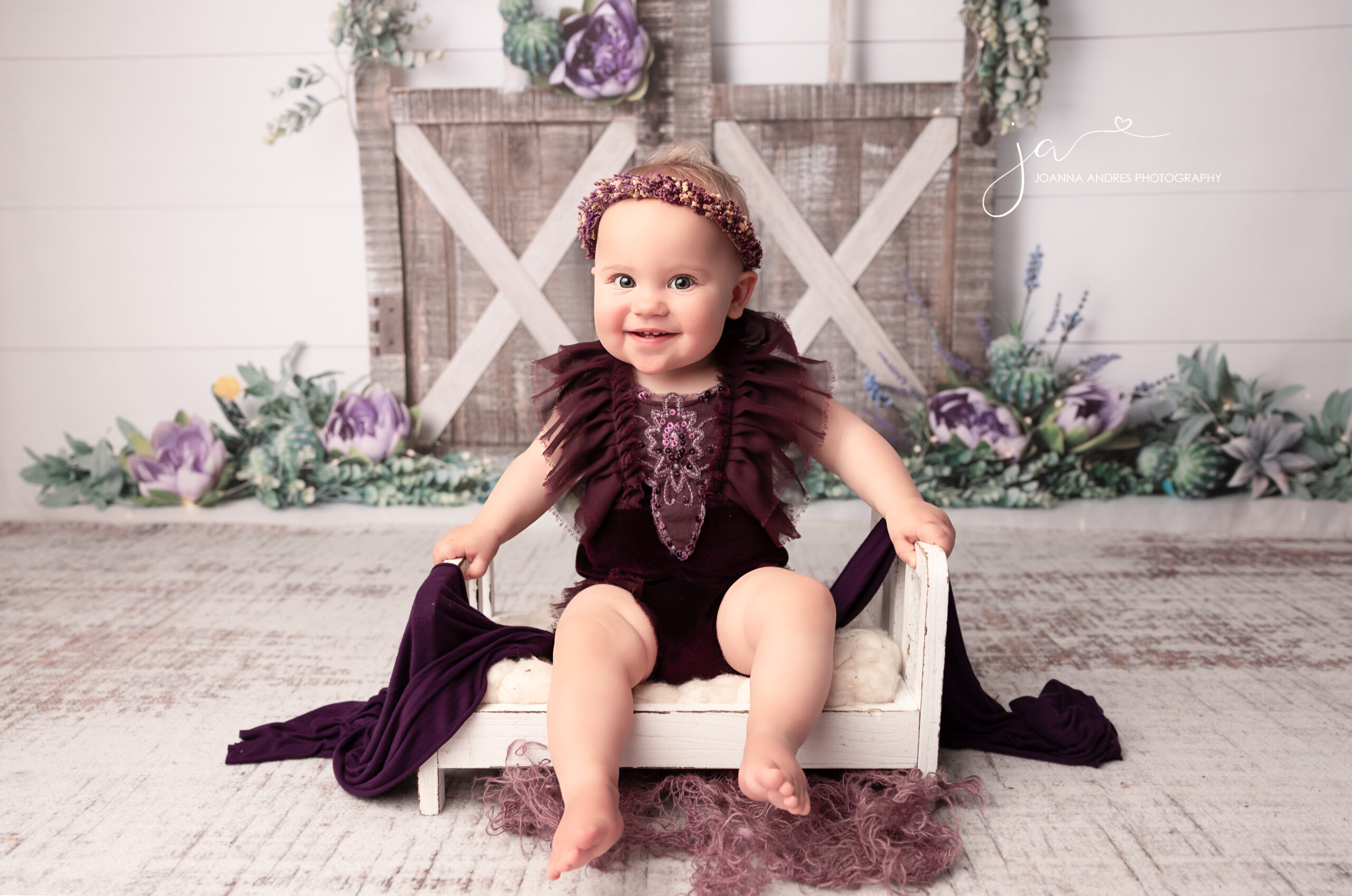 baby wearing purple romper with purple headband