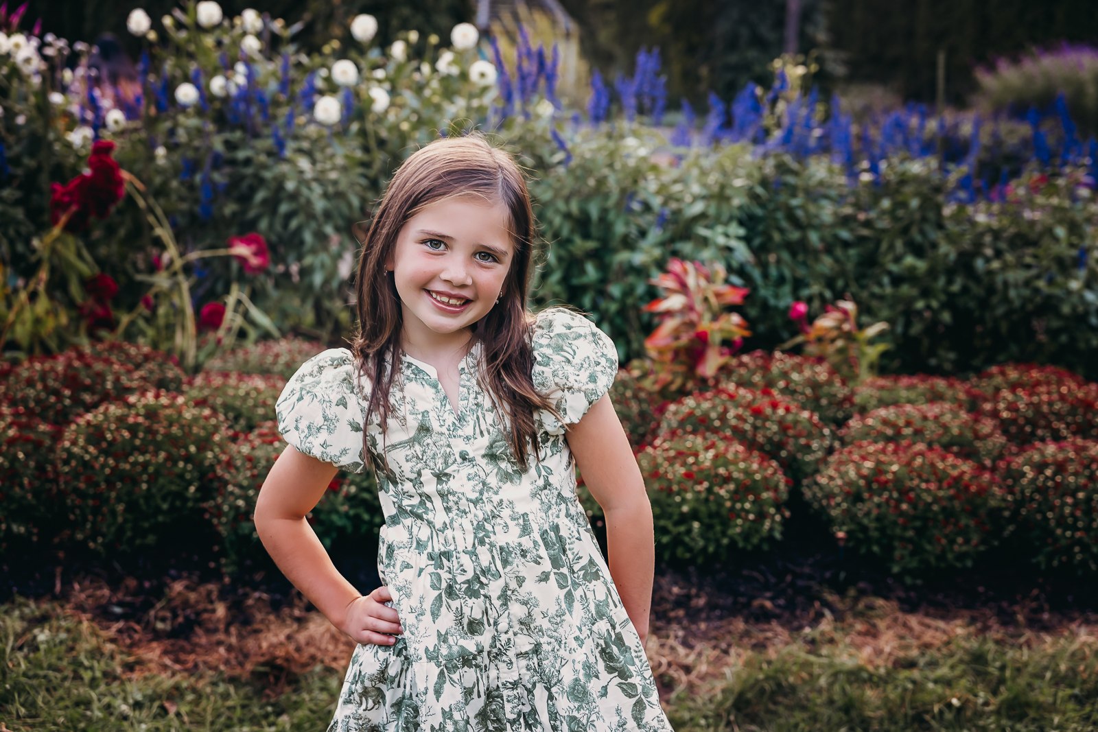 Girl wearing a dress posed in front of florals at Innis Woods Metro Park