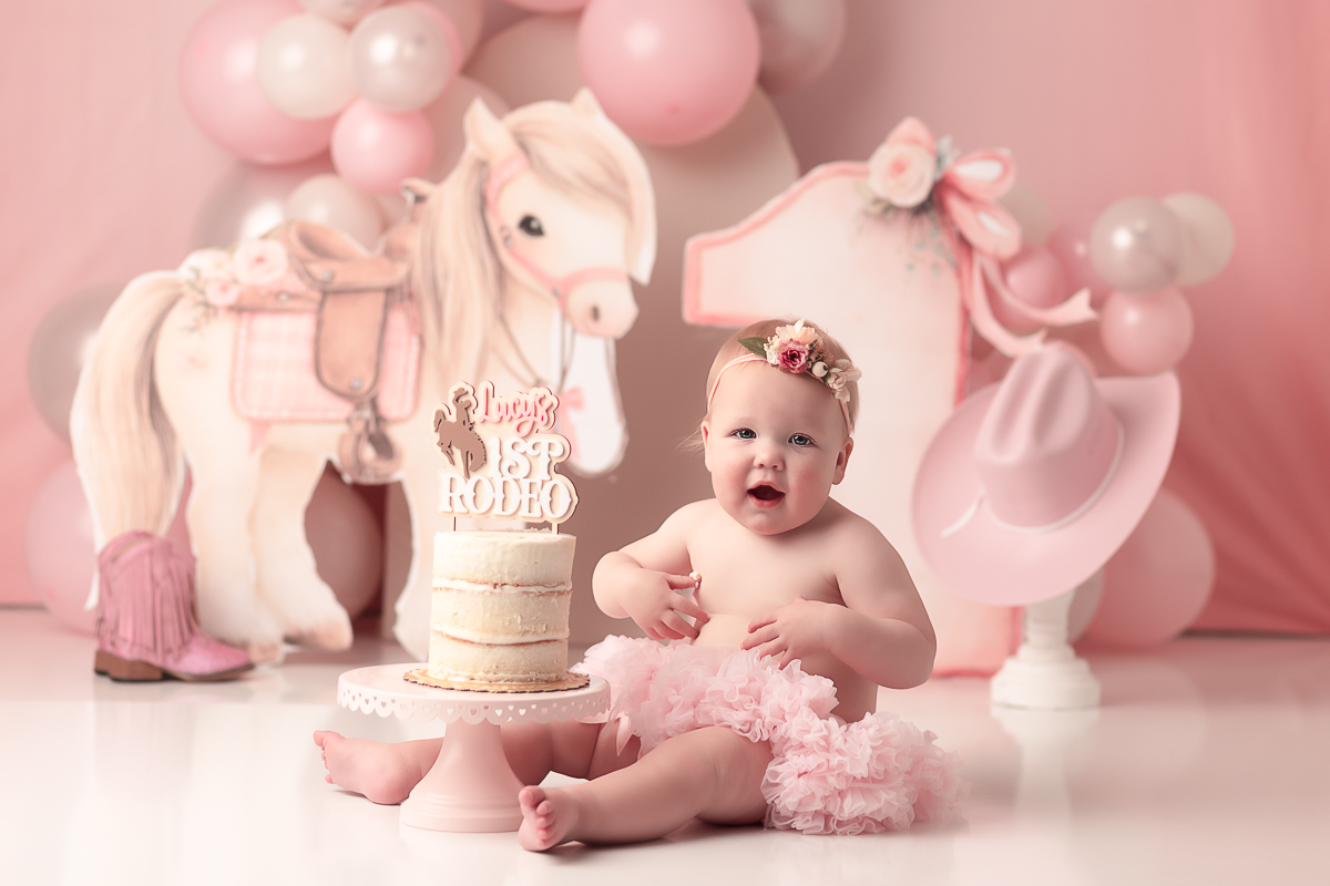 Baby girl in a pink tutu, for a cake smash session theme lucy's 1st Rodeo