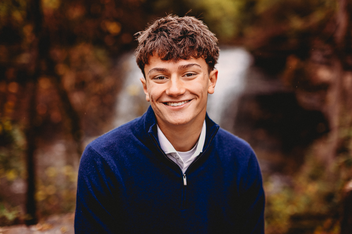 close up senior photo with waterfall backdrop at quarry trails