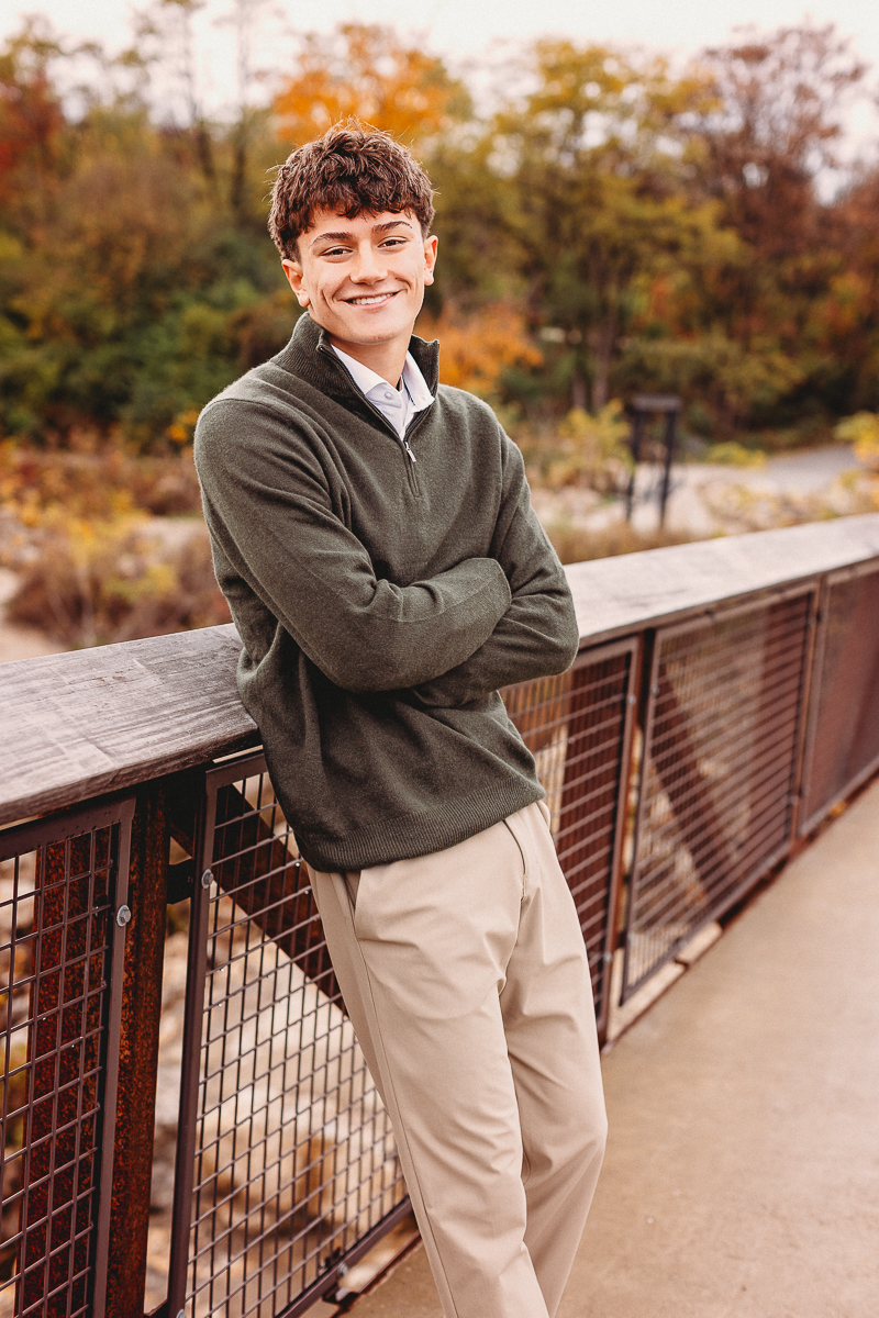 senior pictures taken at quarry trails park of boy crossing his arms